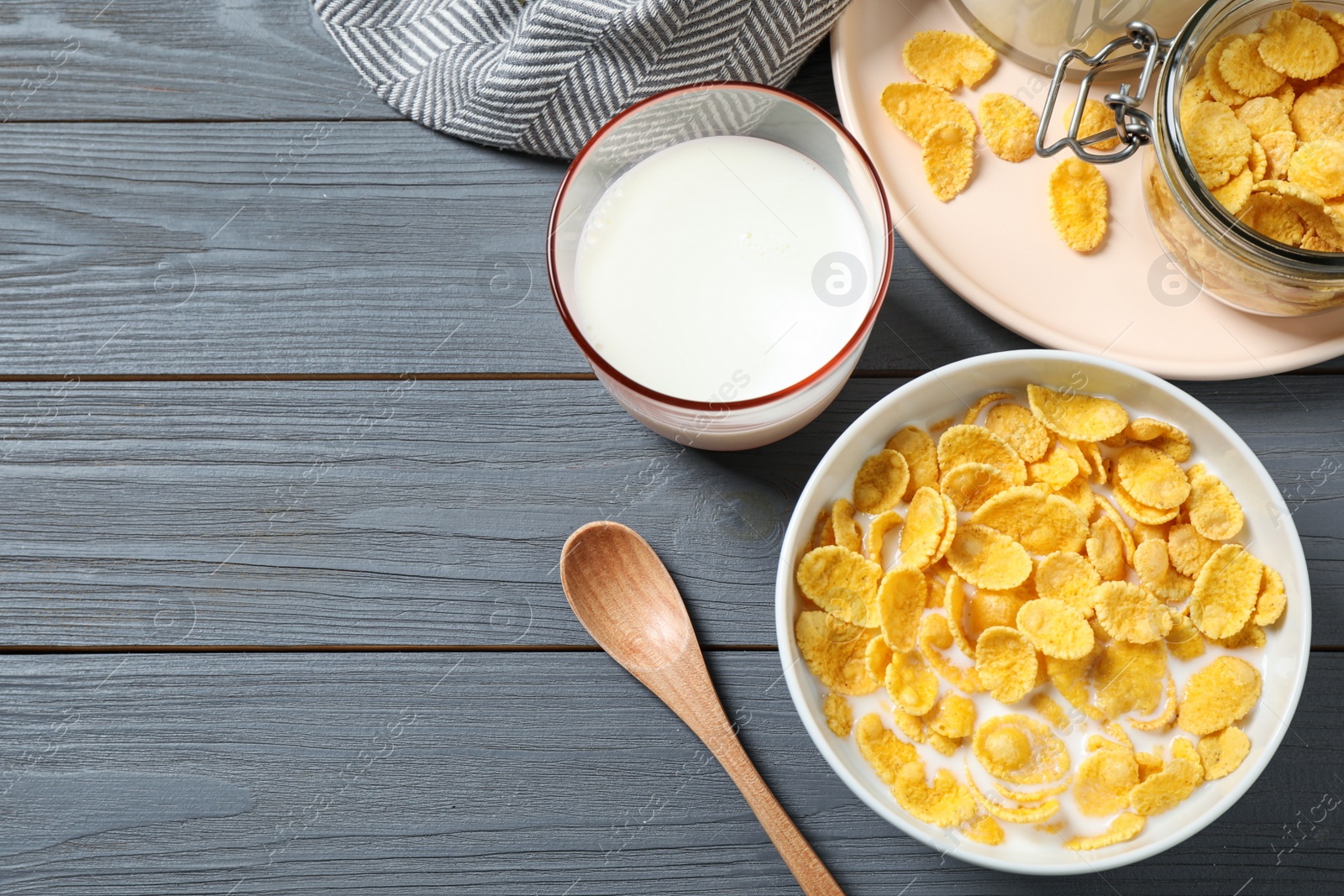 Photo of Flat lay composition with tasty corn flakes on grey wooden table. Space for text