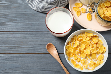 Photo of Flat lay composition with tasty corn flakes on grey wooden table. Space for text