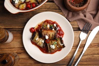 Photo of Tasty eggplant rolls served on wooden table, flat lay