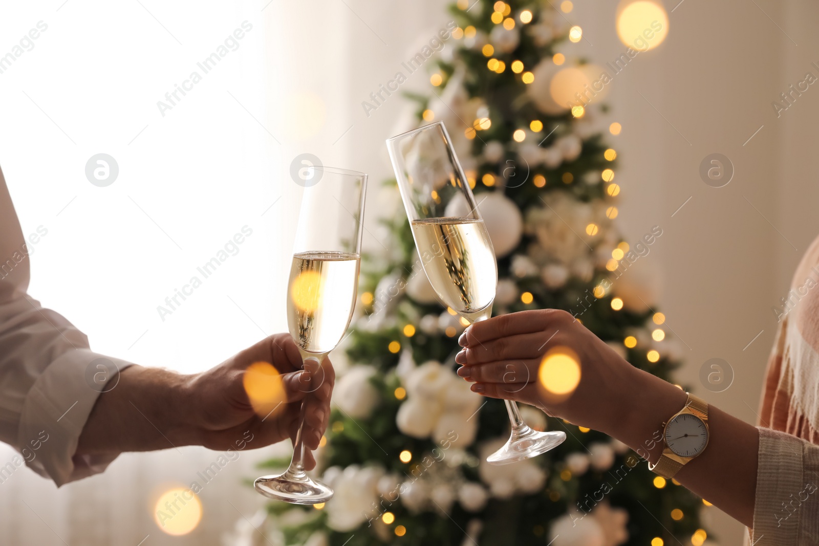 Photo of People clinking glasses with champagne at home, closeup