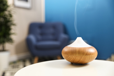 Aroma oil diffuser on white table at home, space for text. Air freshener