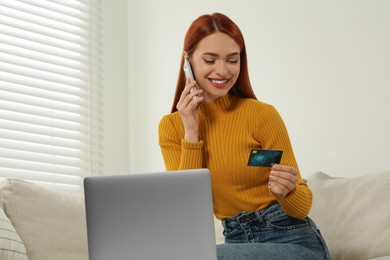 Happy woman with credit card using smartphone for online shopping at home