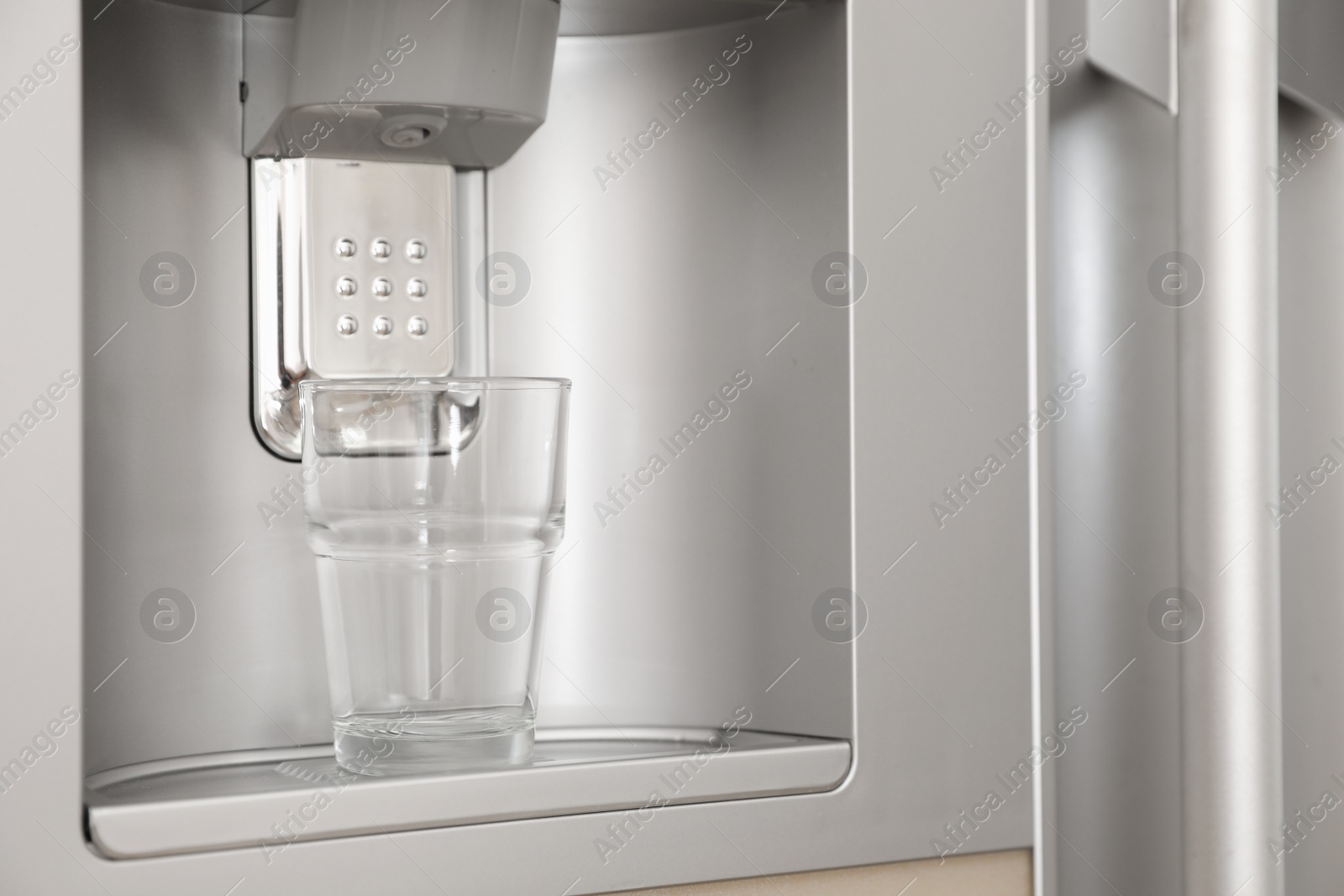 Photo of Refrigerator with ice and water system, closeup. Modern kitchen appliance