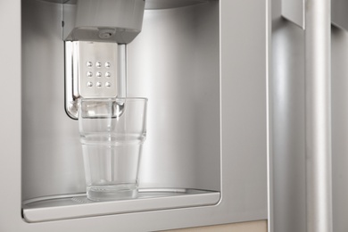 Refrigerator with ice and water system, closeup. Modern kitchen appliance