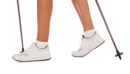 Photo of Woman wearing stylish shoes with trekking poles on white background, closeup