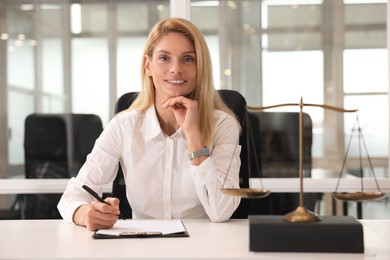 Photo of Portrait of smiling lawyer working at table in office