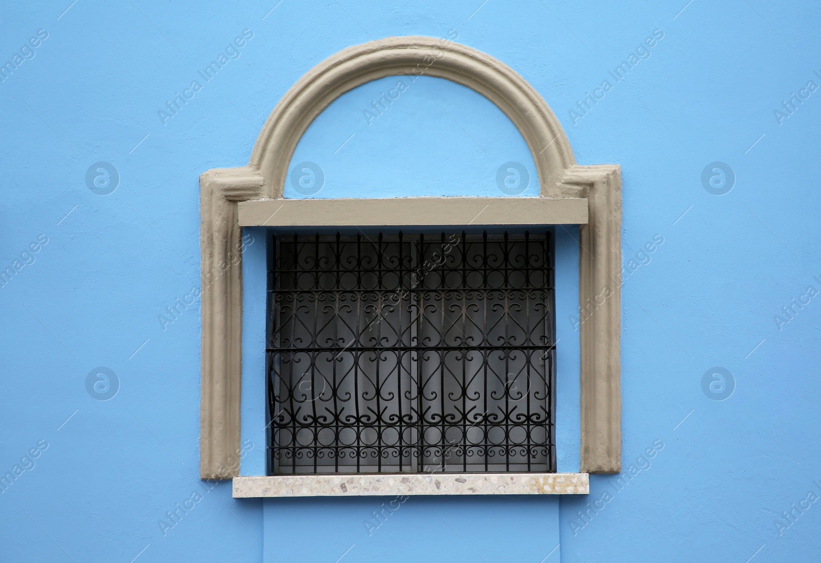 Photo of Blue building with beautiful window and steel grilles