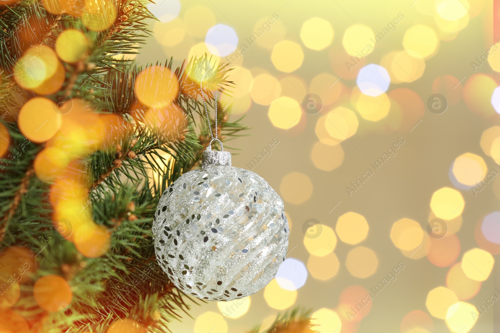 Image of Beautiful bauble hanging on Christmas tree against blurred lights, closeup view with space for text. Bokeh effect