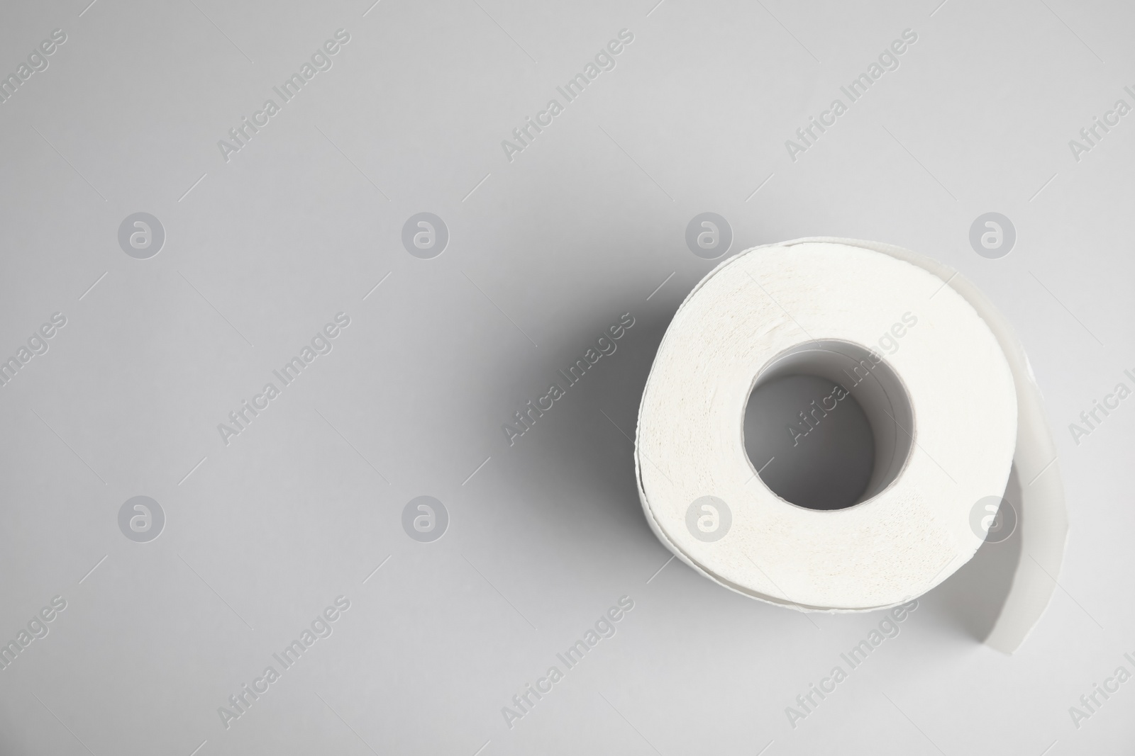 Photo of Toilet paper roll on grey background, top view. Space for text