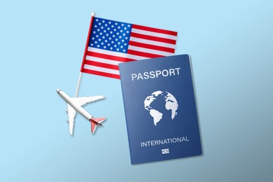 Image of International passport, airplane model and American flag on light blue background, flat lay