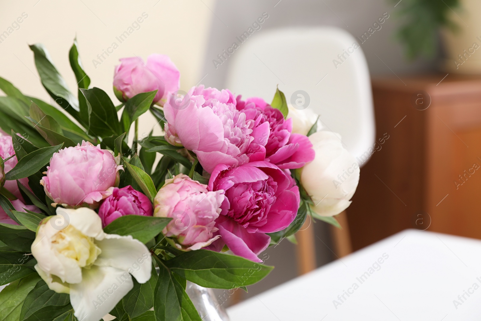 Photo of Bouquet of beautiful peonies on table in room, closeup. Space for text