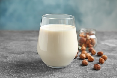 Photo of Glass with hazelnut milk on grey table