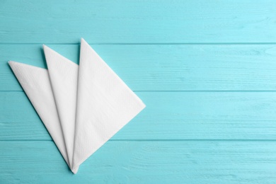 Clean napkins on turquoise wooden table, flat lay. Space for text