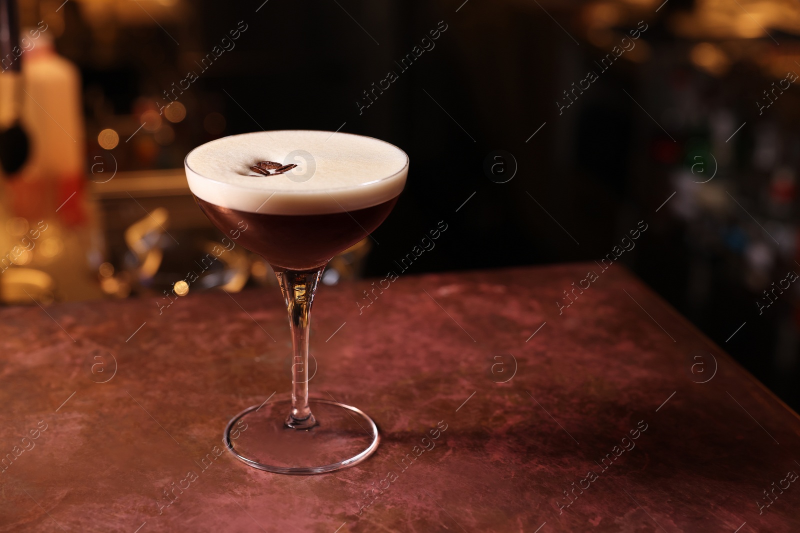 Photo of Glass of delicious Espresso Martini on bar counter, space for text. Alcoholic cocktail