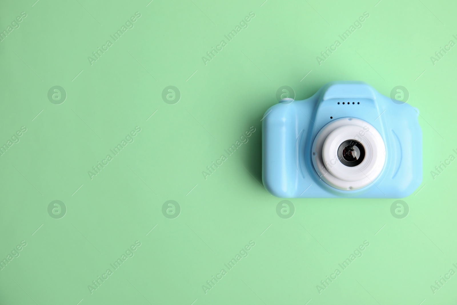 Photo of Light blue toy camera on light green background, top view with space for text. . Future photographer