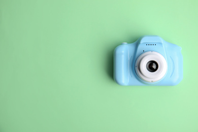 Light blue toy camera on light green background, top view with space for text. . Future photographer