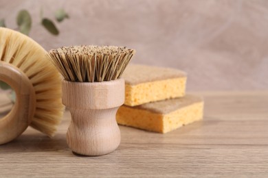 Small cleaning brush on wooden table, closeup. Space for text