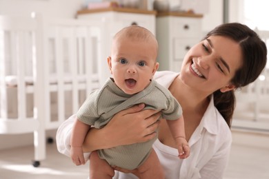 Happy young mother with her cute baby at home