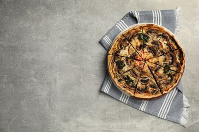 Photo of Delicious quiche with mushrooms on grey table, top view. Space for text