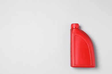 Motor oil in red canister on light background, top view. Space for text