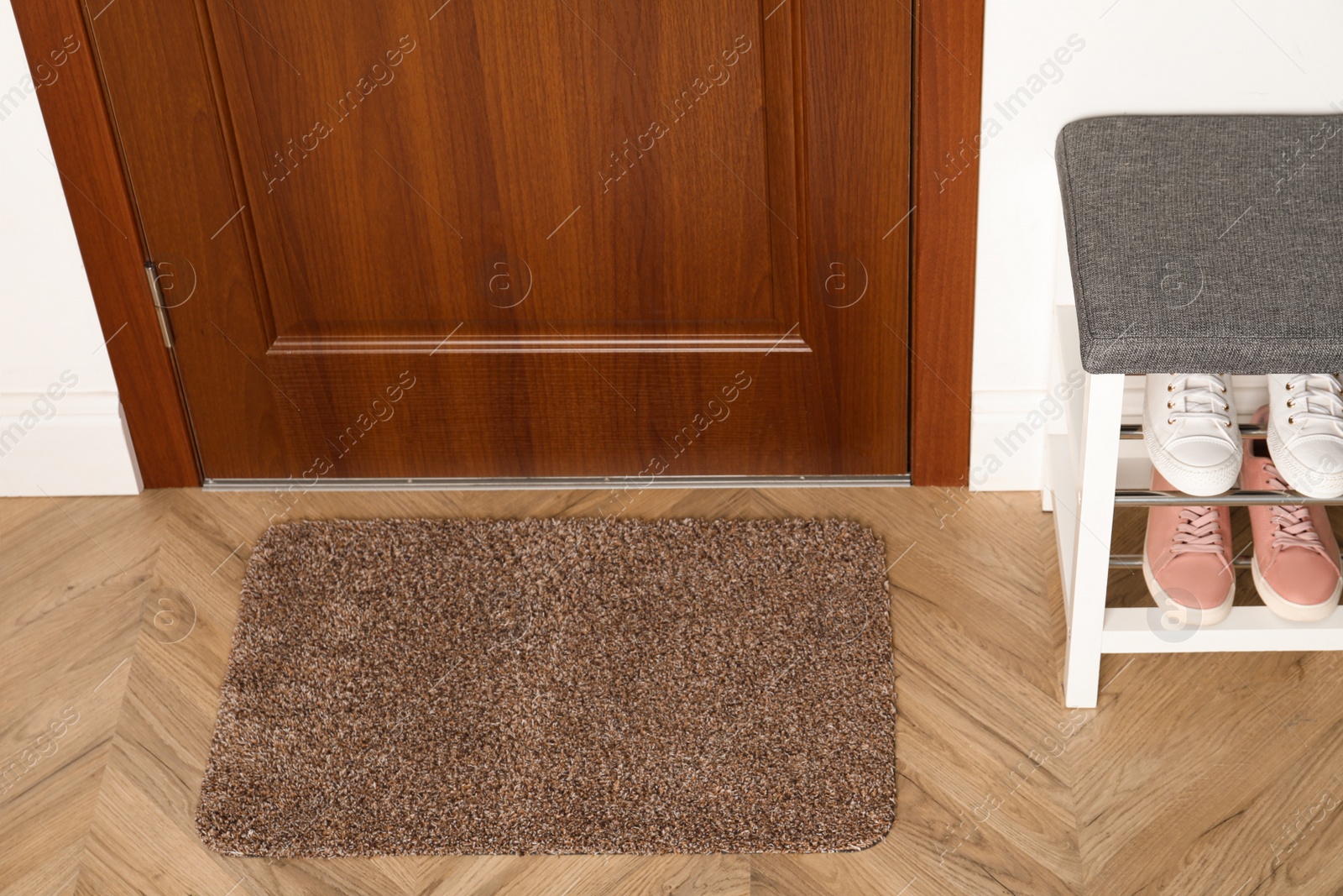 Photo of New clean mat near entrance door and shoes shelf