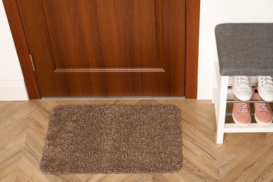 Photo of New clean mat near entrance door and shoes shelf