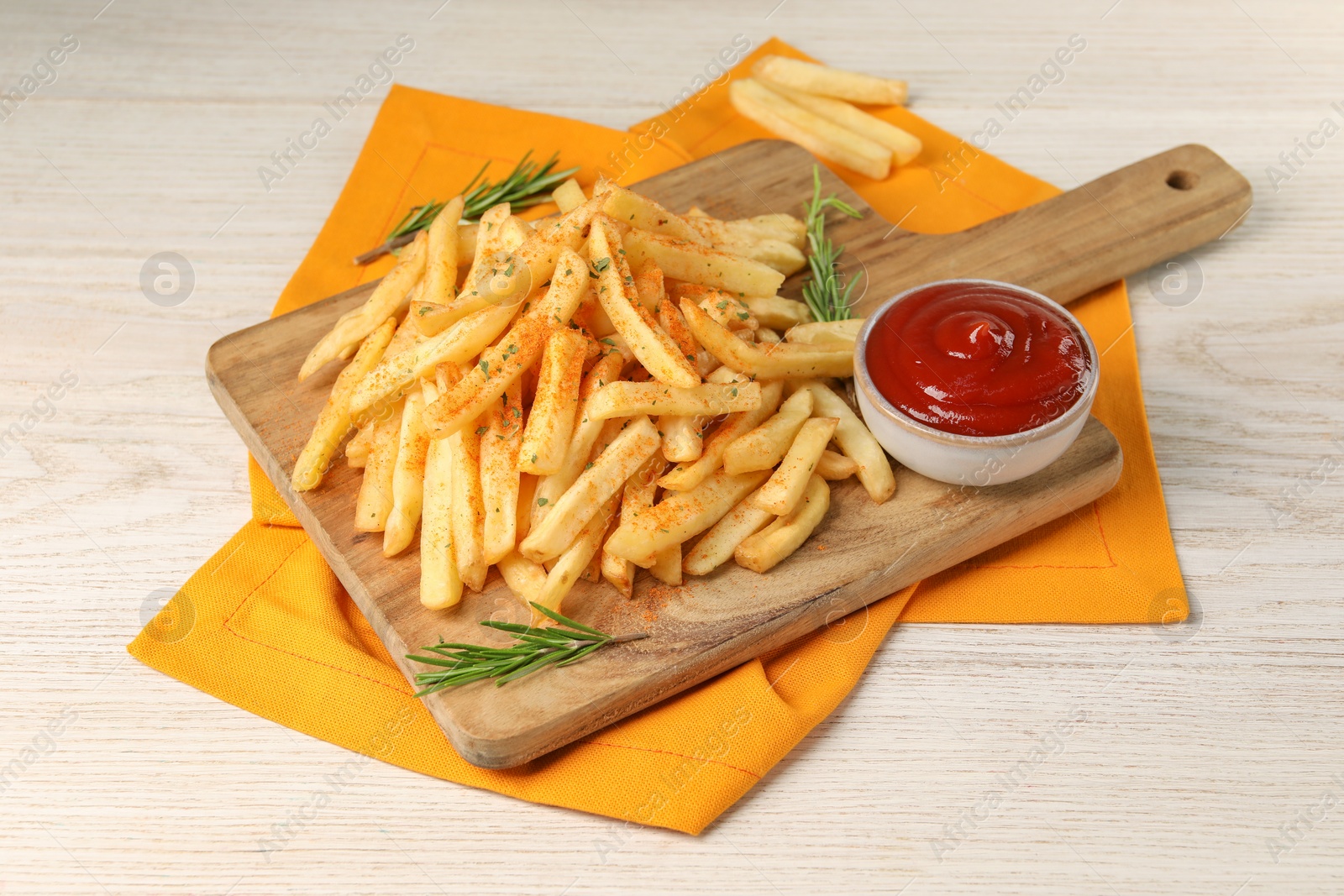 Photo of Delicious french fries served with sauce on white wooden table