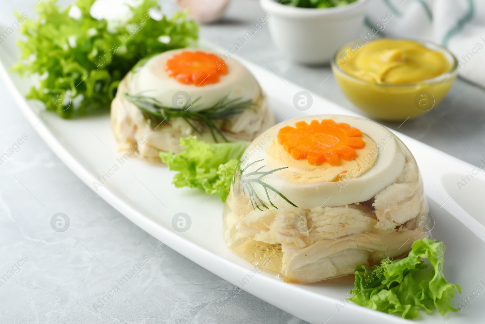 Photo of Delicious chicken aspic served on light grey table, closeup