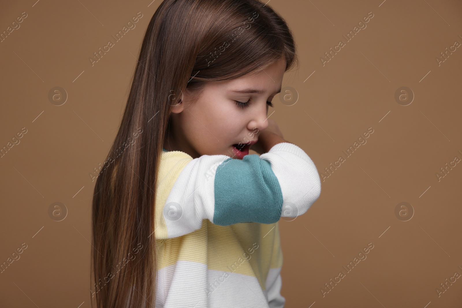 Photo of Sick girl coughing on brown background. Cold symptoms