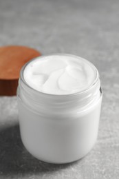 Photo of Jar of face cream on grey table, closeup