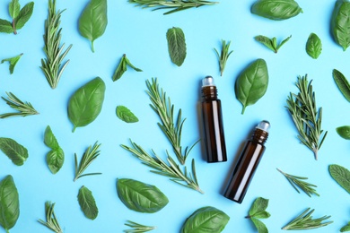 Flat lay composition with herbal essential oils on light blue background