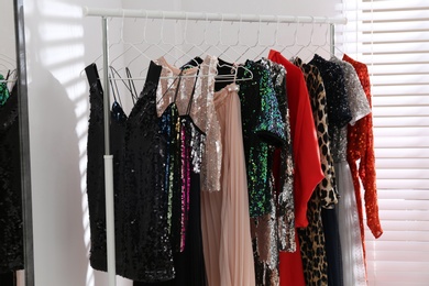 Different stylish women's clothes on rack indoors