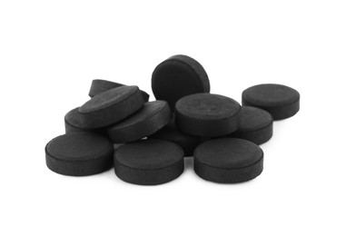 Photo of Activated charcoal pills on white background. Potent sorbent