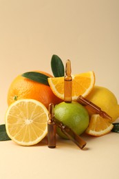 Skincare ampoules with vitamin C, different citrus fruits and leaves on beige background