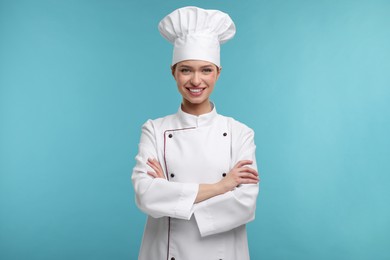 Happy chef in uniform on light blue background