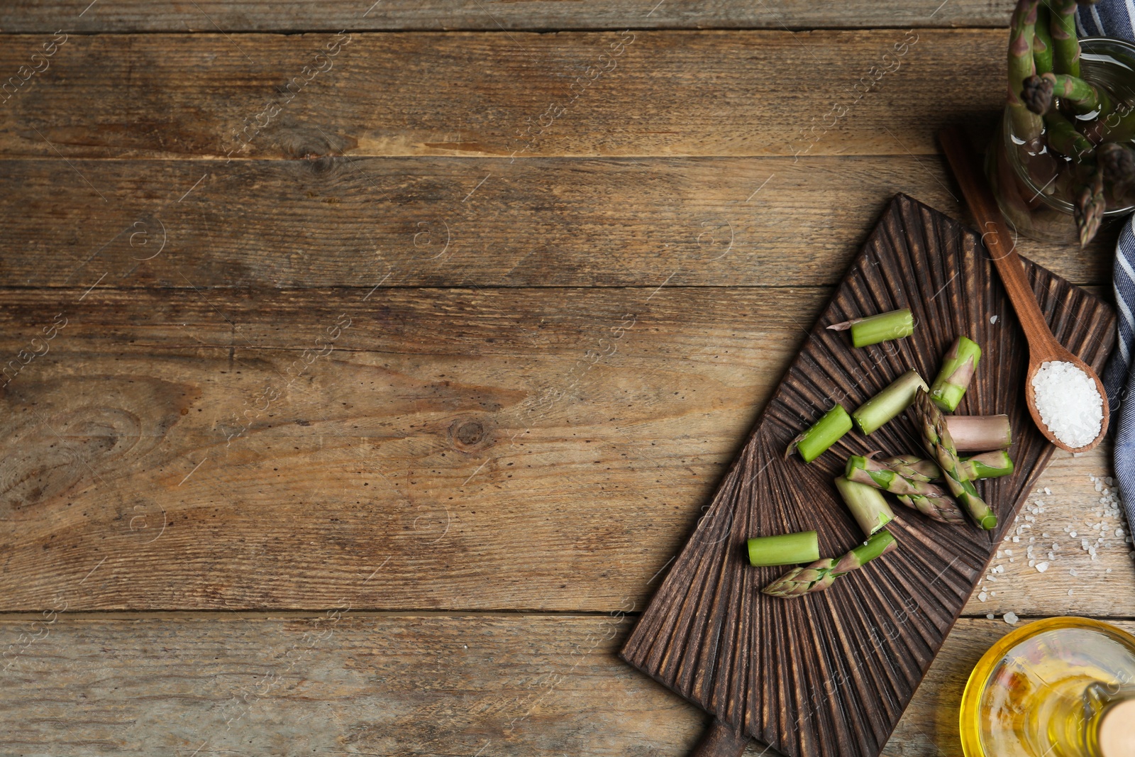 Photo of Fresh raw asparagus on wooden table, flat lay. Space for text