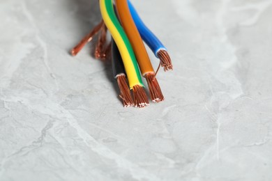 Photo of Colorful electrical wires on gray textured surface, closeup. Space for text