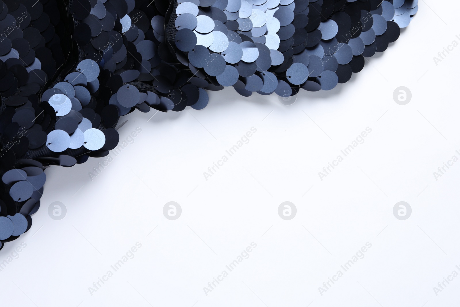 Photo of Beautiful shiny sequin fabric on white background, top view. Space for text