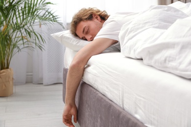 Photo of Handsome young man sleeping on pillow at home. Bedtime