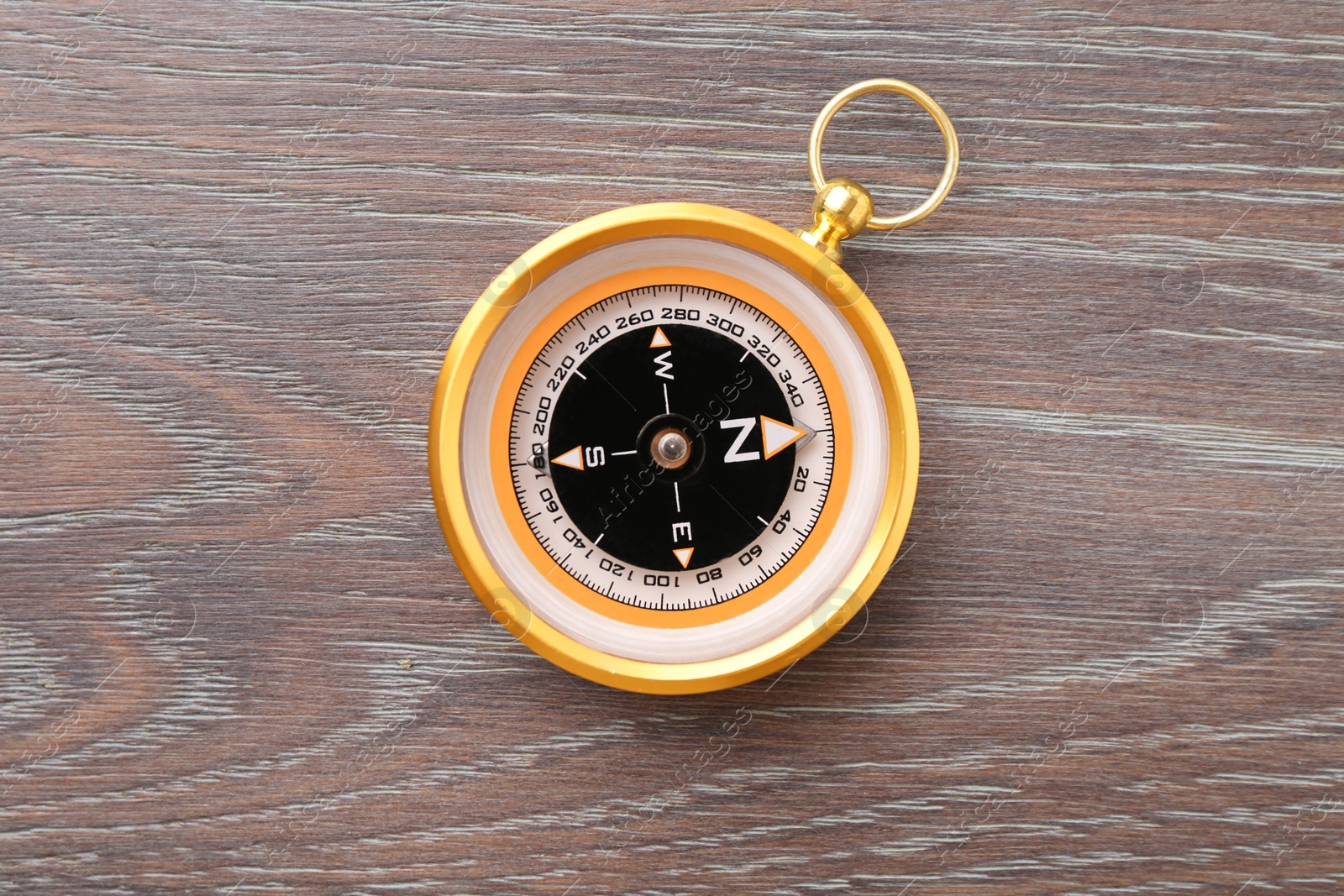 Photo of One compass on wooden table, top view