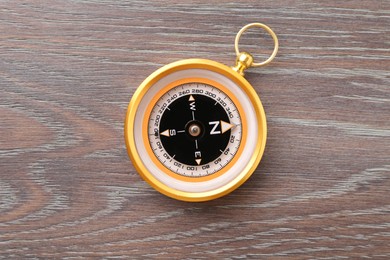 One compass on wooden table, top view