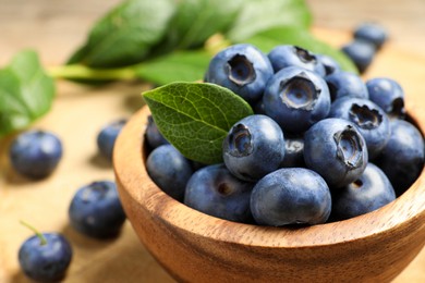 Photo of Bowl of fresh tasty blueberries on table, closeup. Space for text