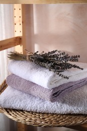 Stacked soft towels and lavender on shelf indoors