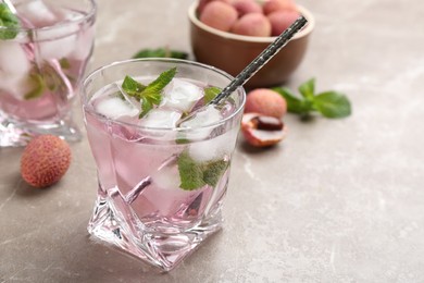 Photo of Lychee cocktail with mint and ice on grey table, closeup
