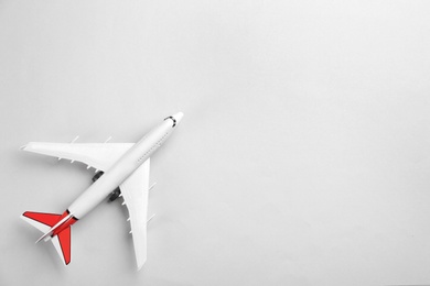 Toy airplane on light grey background, top view. Space for text