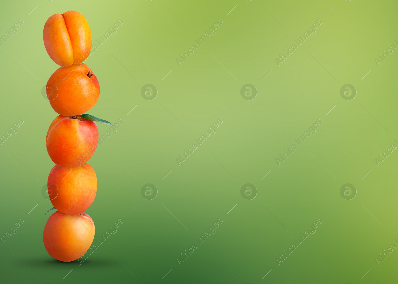 Image of Stack of fresh ripe apricots on green gradient background. Space for text