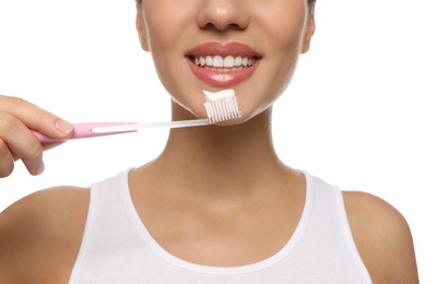 Photo of Woman holding toothbrush with paste on white background, closeup