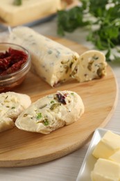 Photo of Tasty bread with butter, green onion, chili peppers and olives on wooden table