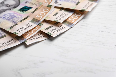 Ukrainian money on white wooden background, closeup. Space for text