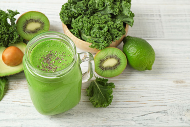 Photo of Tasty fresh kale smoothie on white wooden table